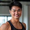 Happy client Park Seo-jun posing at the gym with a determined smile.